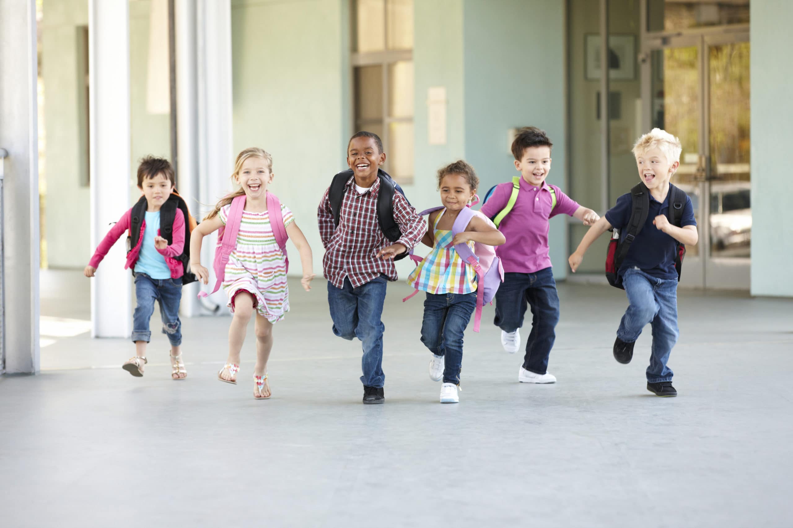 Group Of Elementary Age Schoolchildren Running Outside